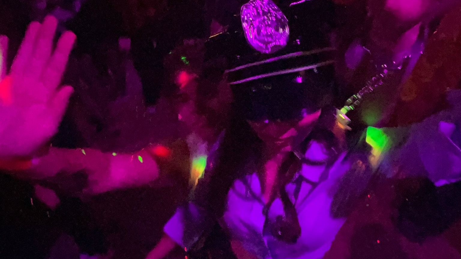 Friends dancing under purple party lights