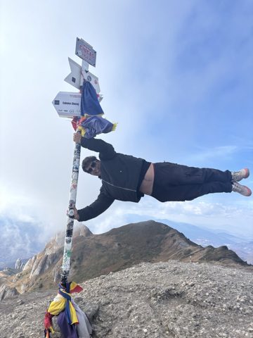 A hiker holding on to a trail sign