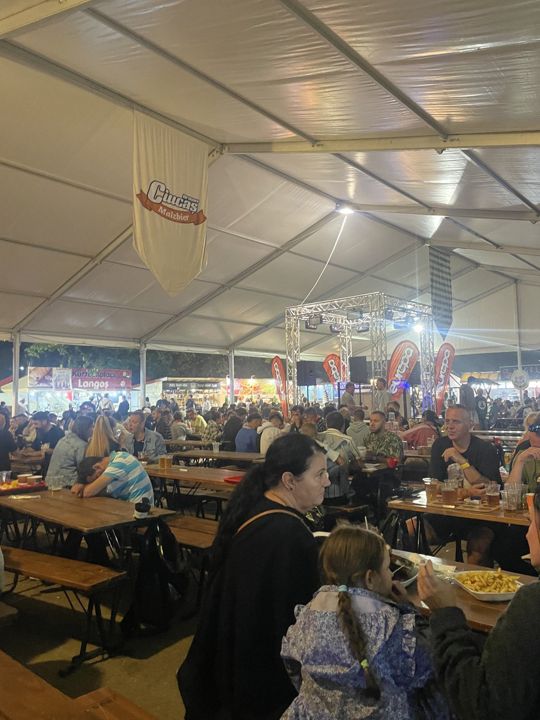 A busy event tent full of guests at long tables