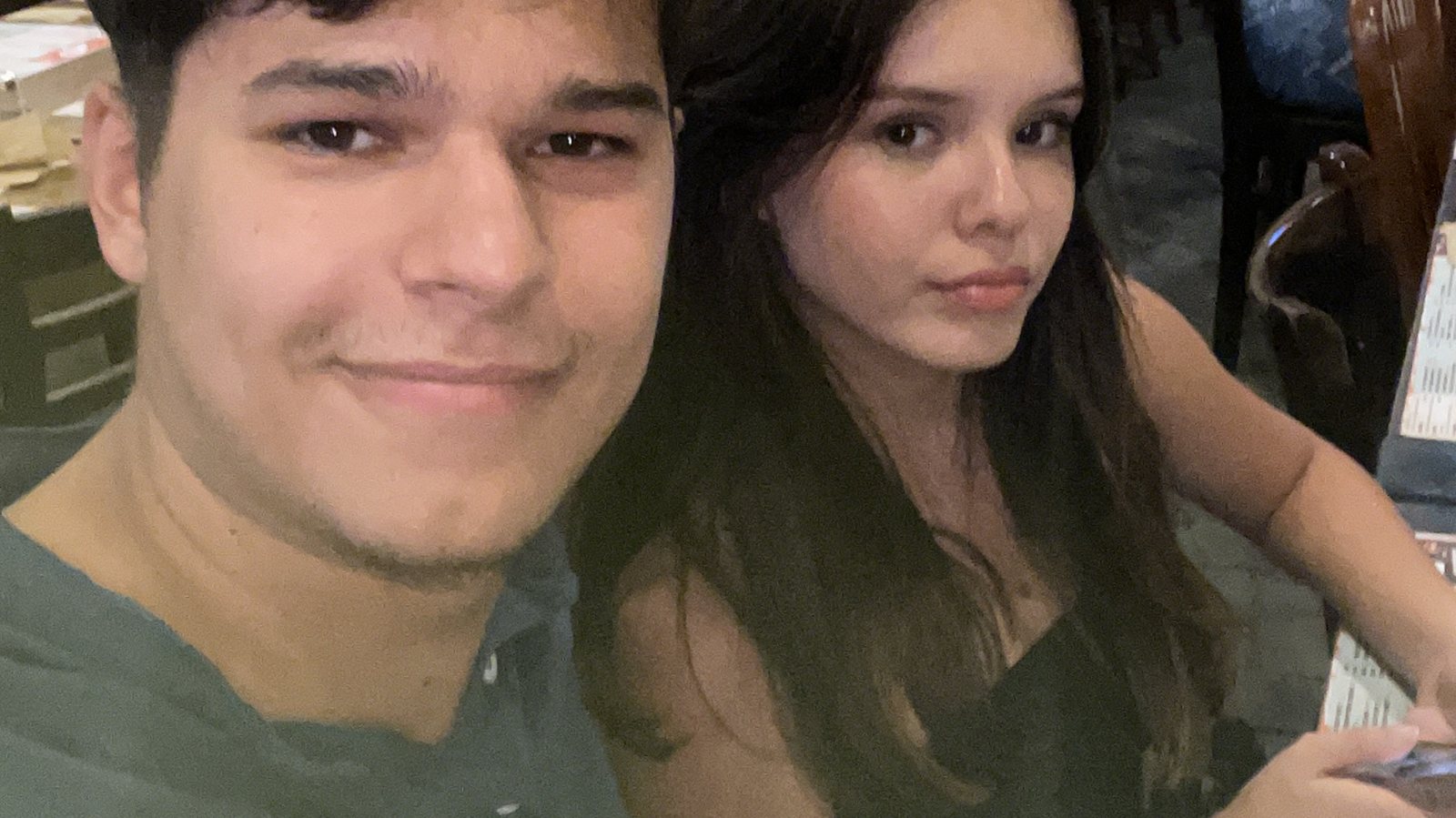 Two friends taking a selfie at a busy party