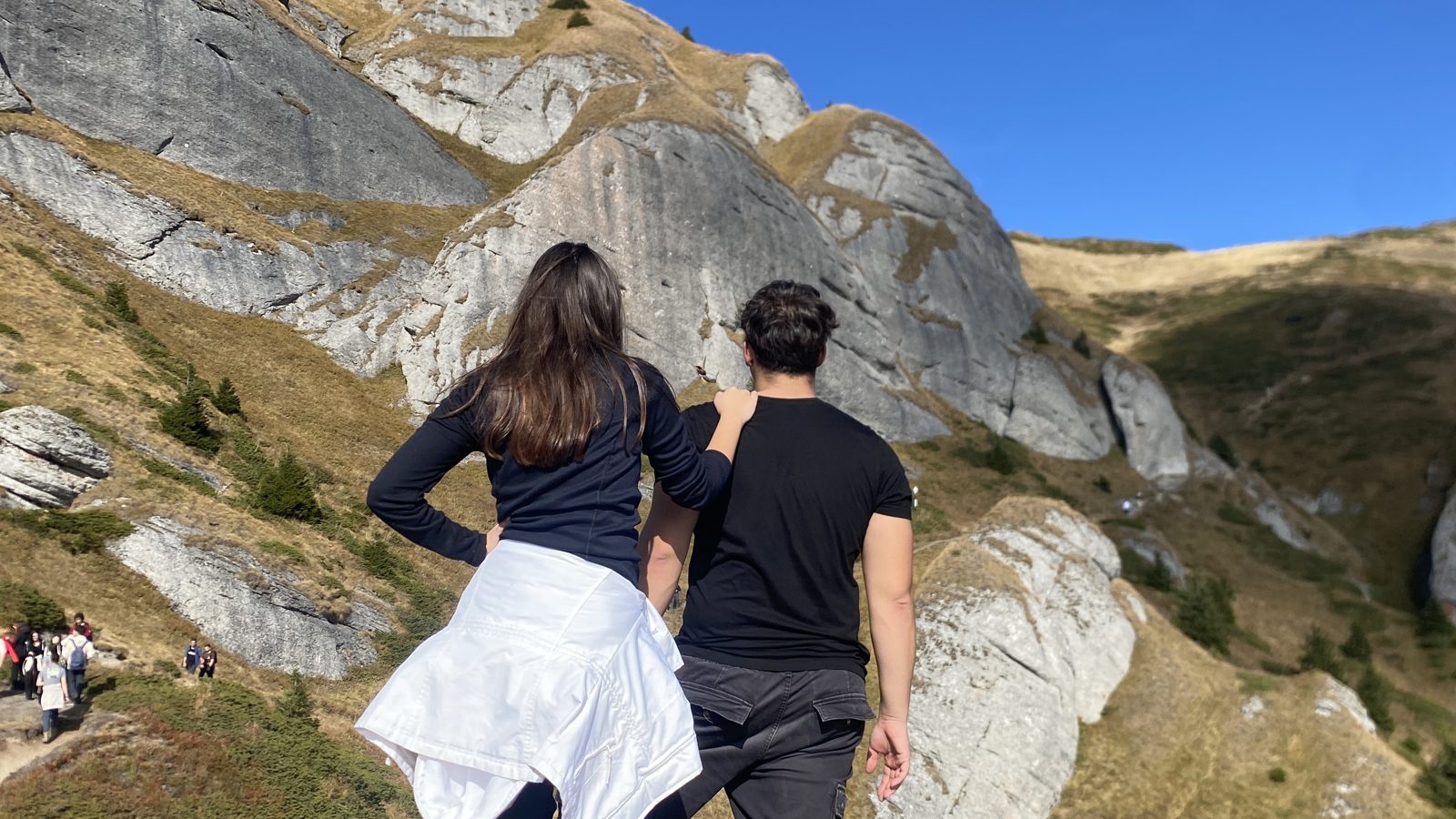 Two hikers walking up towards the rocks