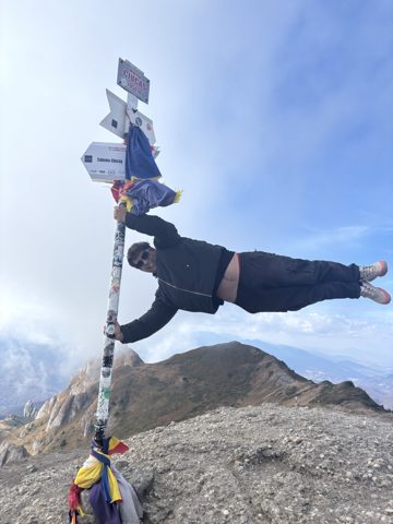 A hiker holding on to a trail sign